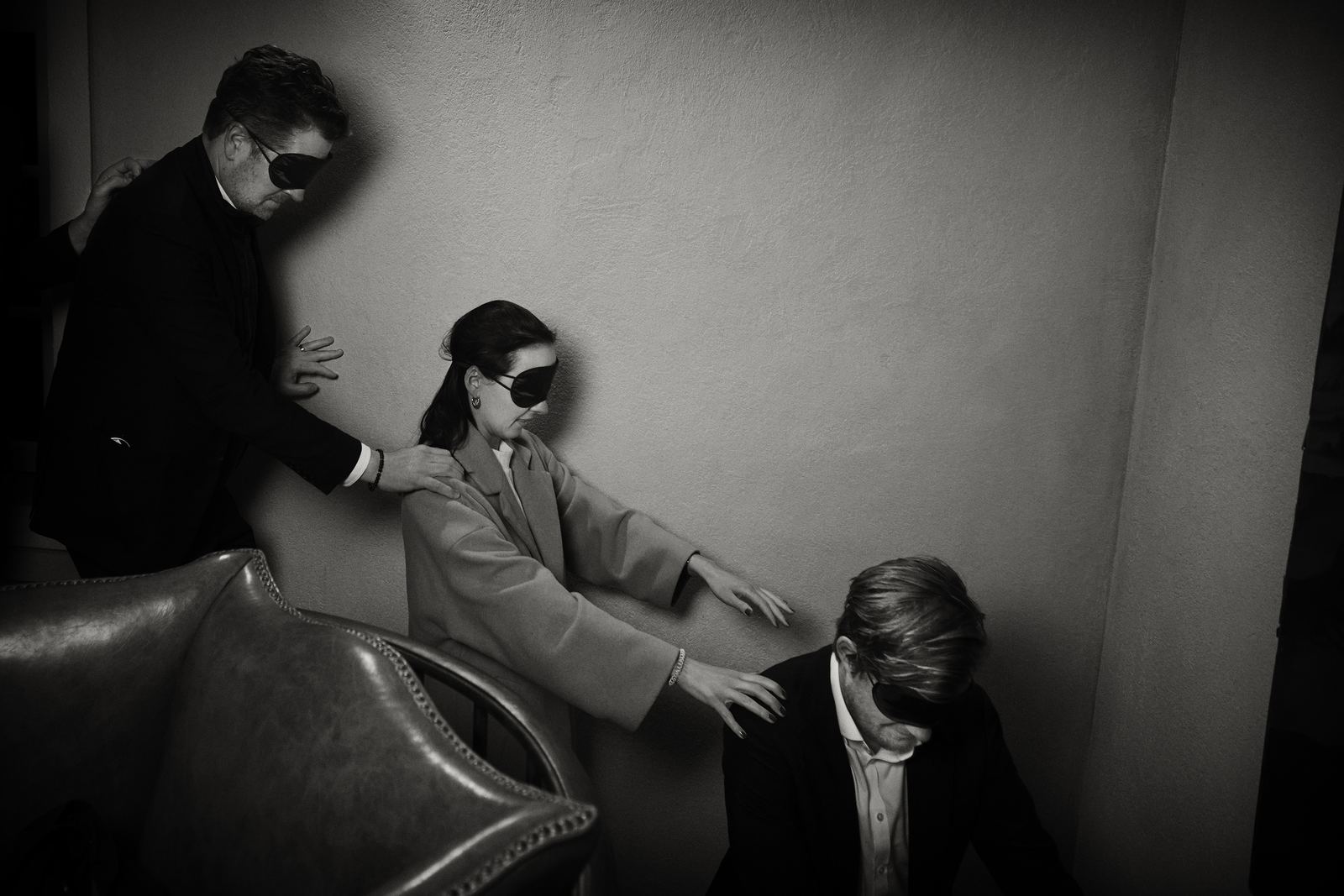 Blindfolded guests being guided along a wall towards the Tabula Rasa dining room