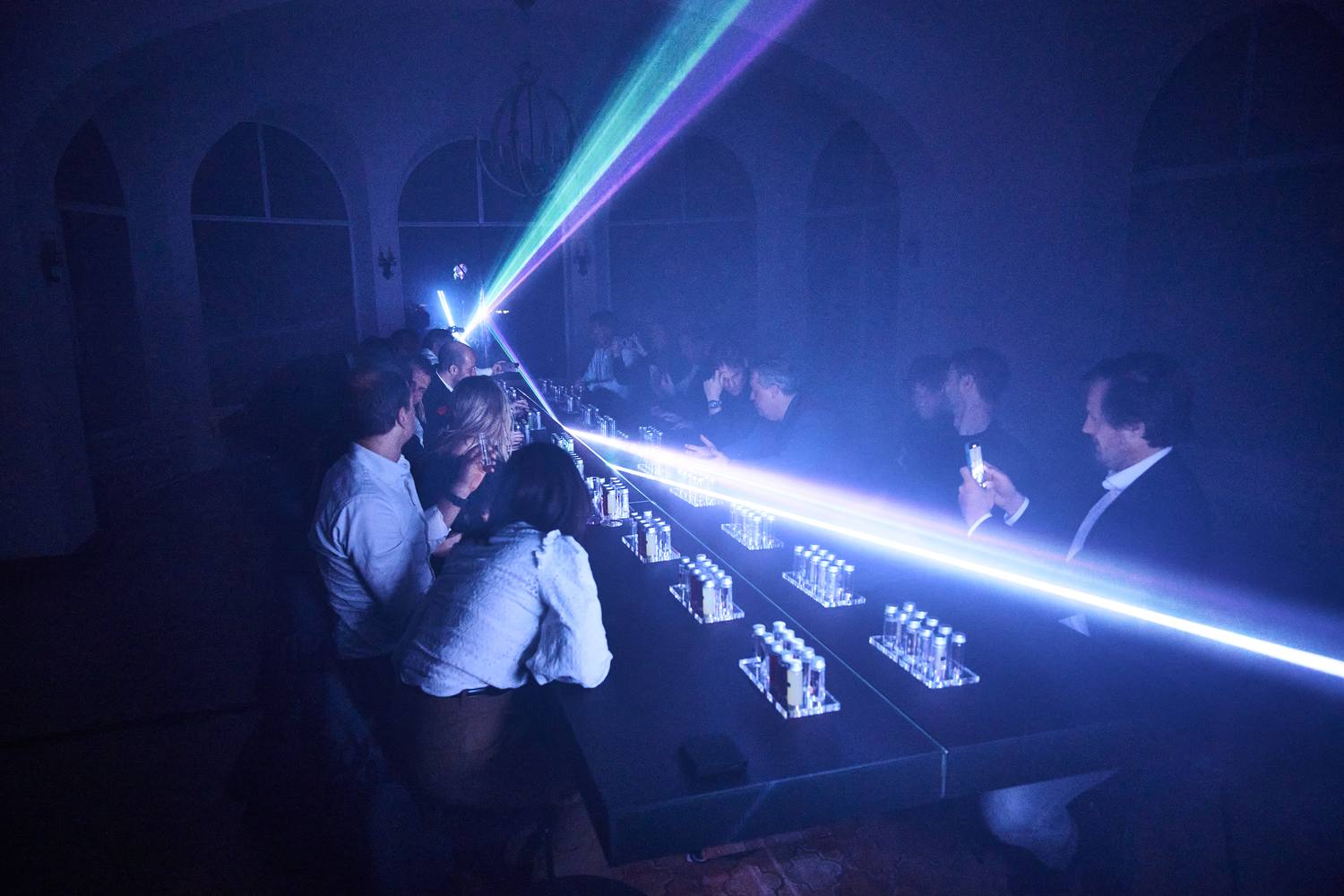 Beams of light crossing the room above the guests during the light and sound composition by Boris Acket