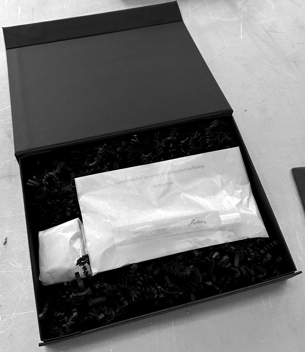The Tabula Rasa package: a black box holding the perfume in glassine paper and the wrapped scent stone