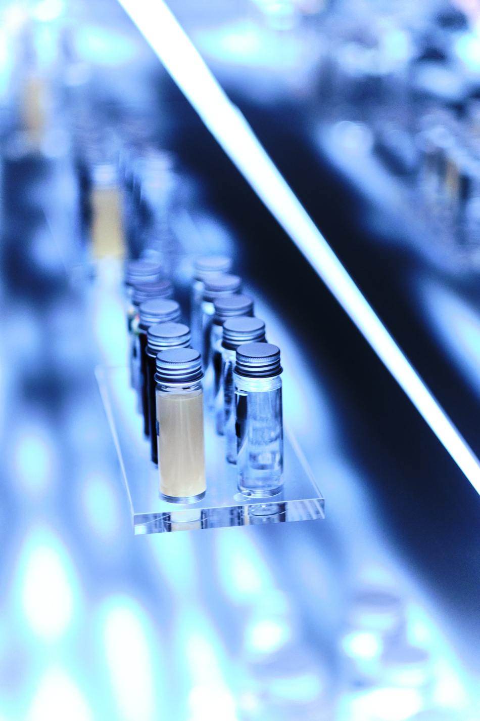 Glass vials on an acrylic tray standing on the illuminated surface of the table